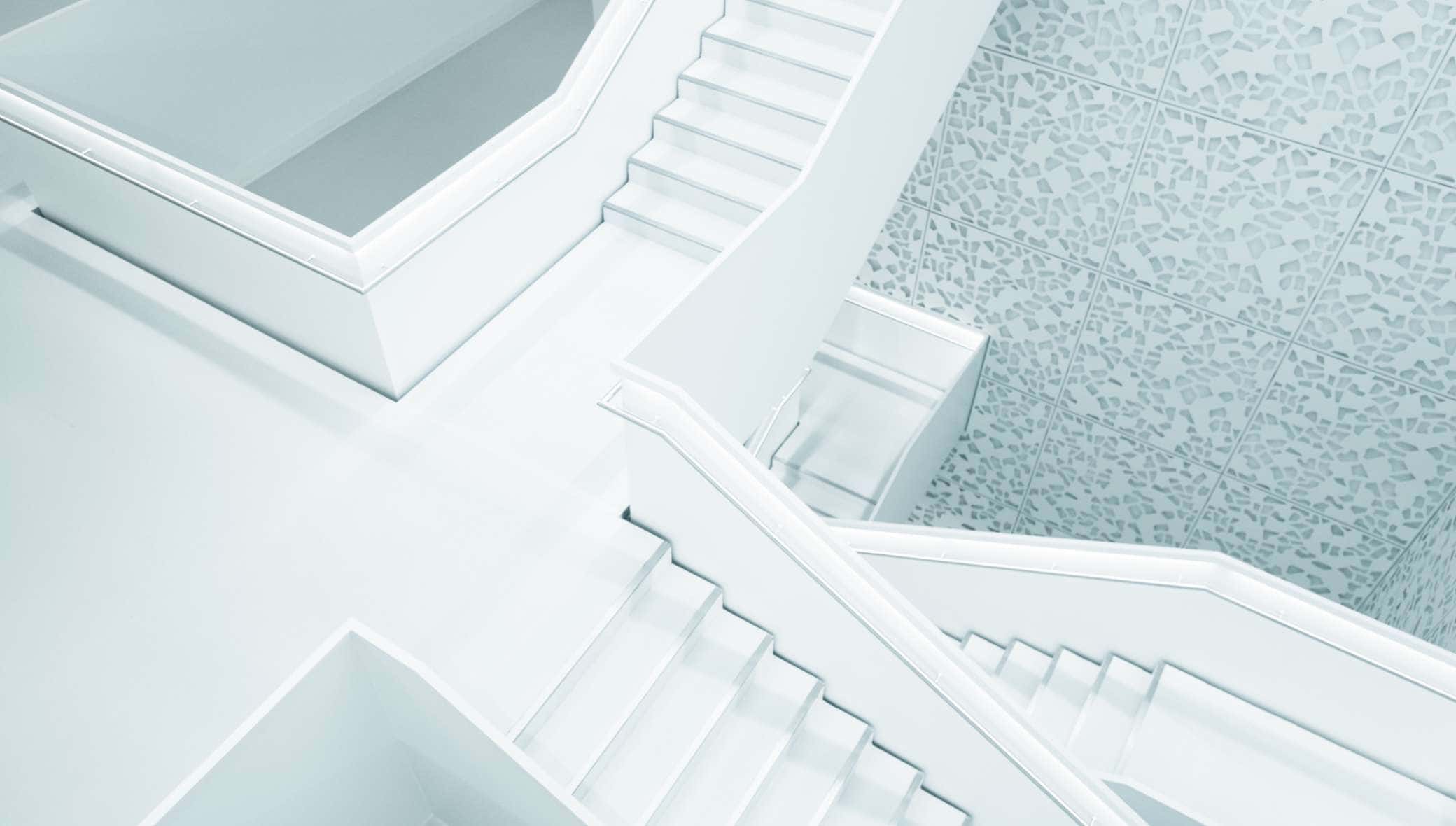 A white staircase with a glass floor in the background.